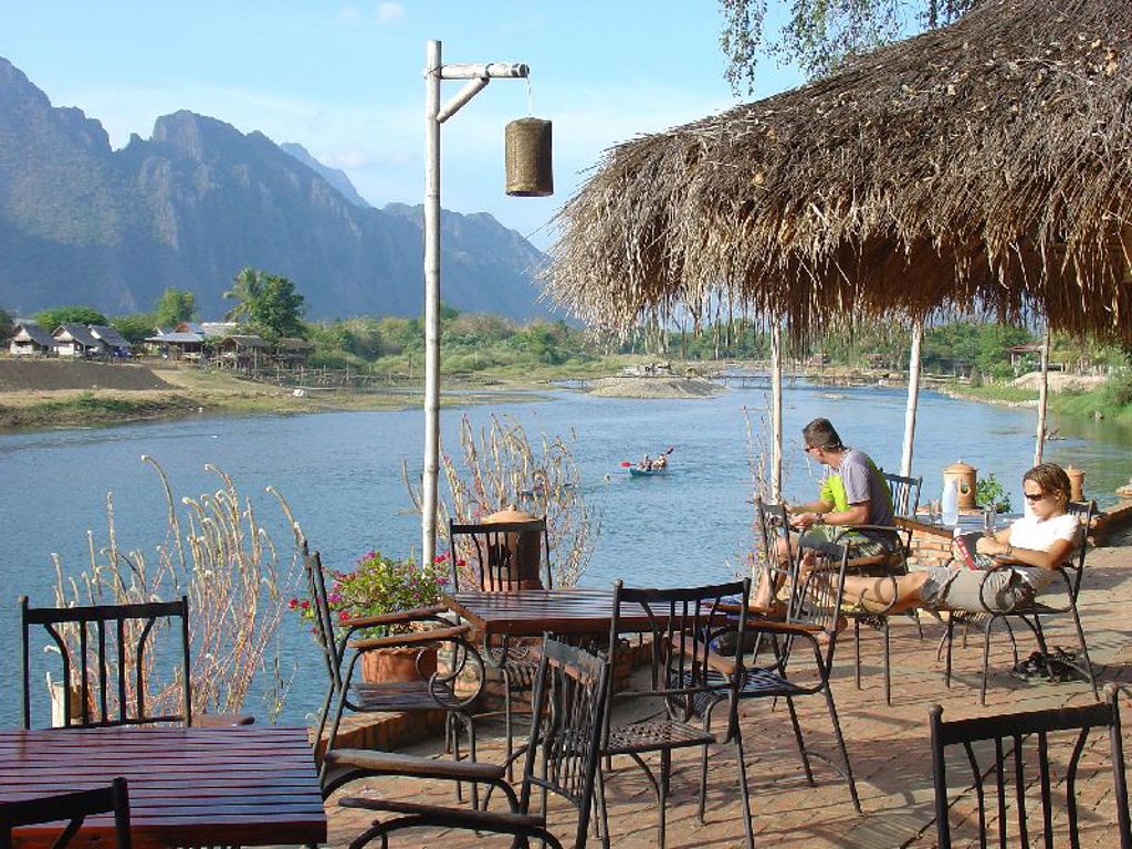 Terras aan de rivier bij Vang Vieng in Laos, met uitzicht op karstbergen tijdens groepsrondreis Laos & Cambodja.