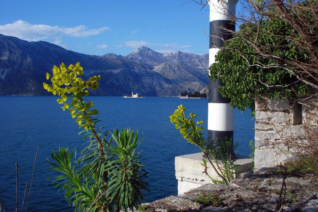 Uitzicht over de Baai van Kotor in Montenegro met bergen en eilandjes, tijdens een wandelvakantie.