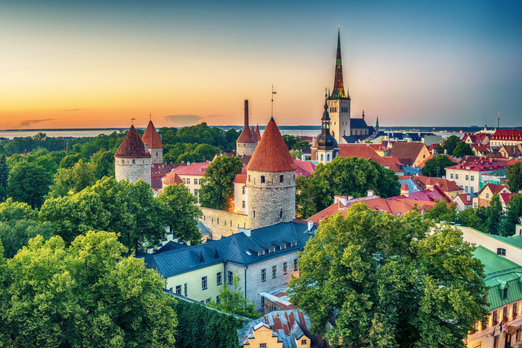 Uitzicht op de middeleeuwse binnenstad van Tallinn met stadsmuren en torens bij zonsondergang, Estland.