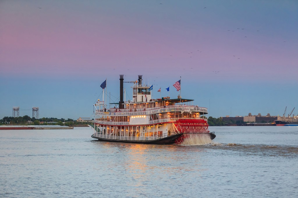 Raderboot vaart over de Mississippi bij zonsondergang in New Orleans, Verenigde Staten.