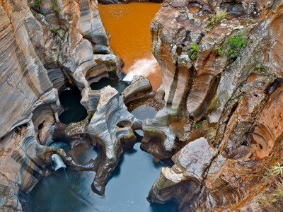 Bourke’s Luck Potholes in de Blyde River Canyon, met uitgesleten rotskolken en stromend water.