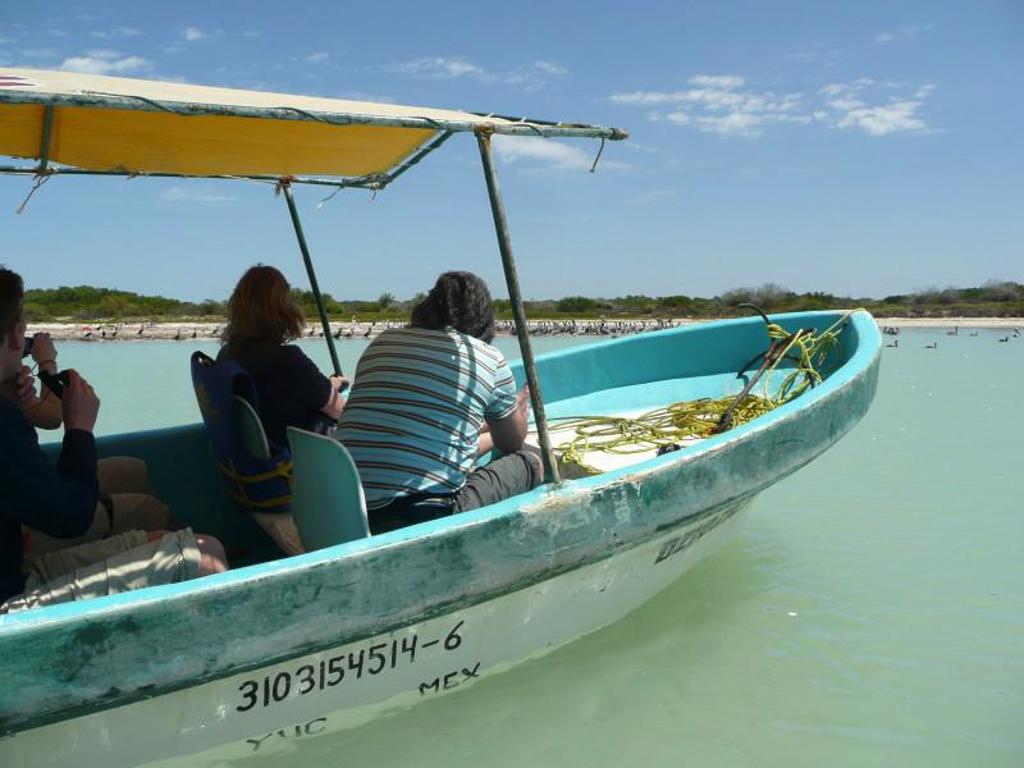 Boottocht over een lagune in Mexico tijdens een familiereis, met passagiers onder een afdak.
