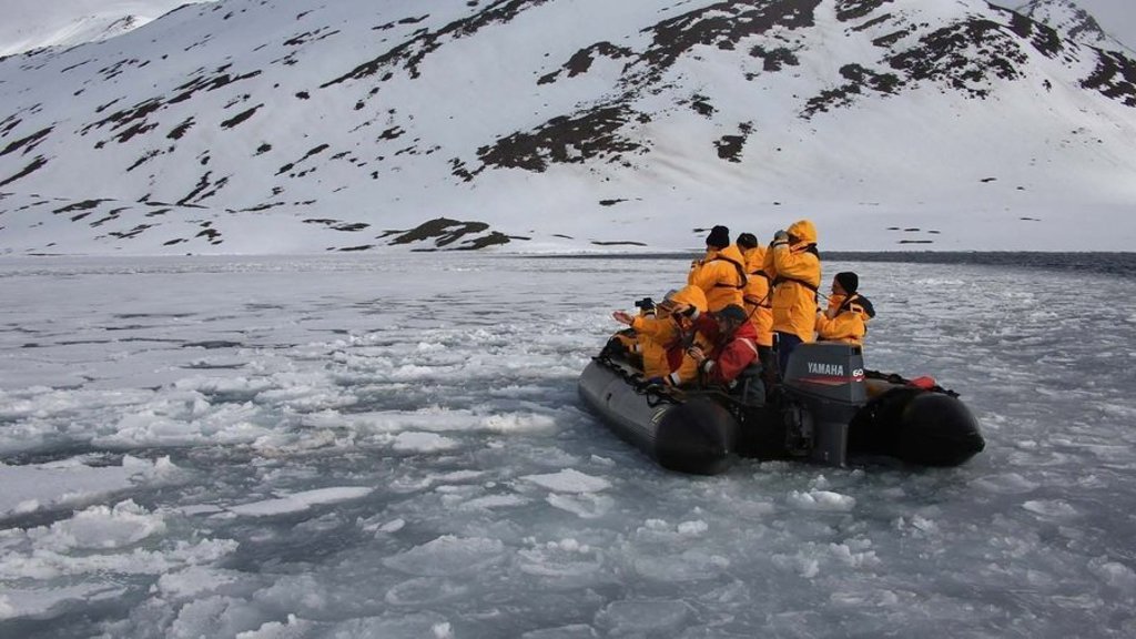 Poollandschap met besneeuwde bergen en drijvend zee-ijs tijdens een groepsrondreis naar de Noordpool.