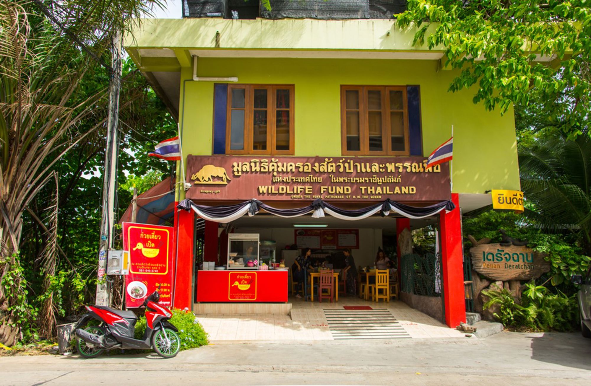 Ingang van het Wildlife Fund Thailand in Khao Sok, met balie en Thaise vlaggen.