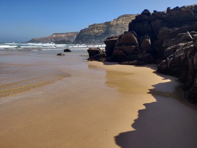 Zandstrand met rotsformaties en kliffen aan de Costa Vicentina in de Alentejo en Algarve, Portugal.