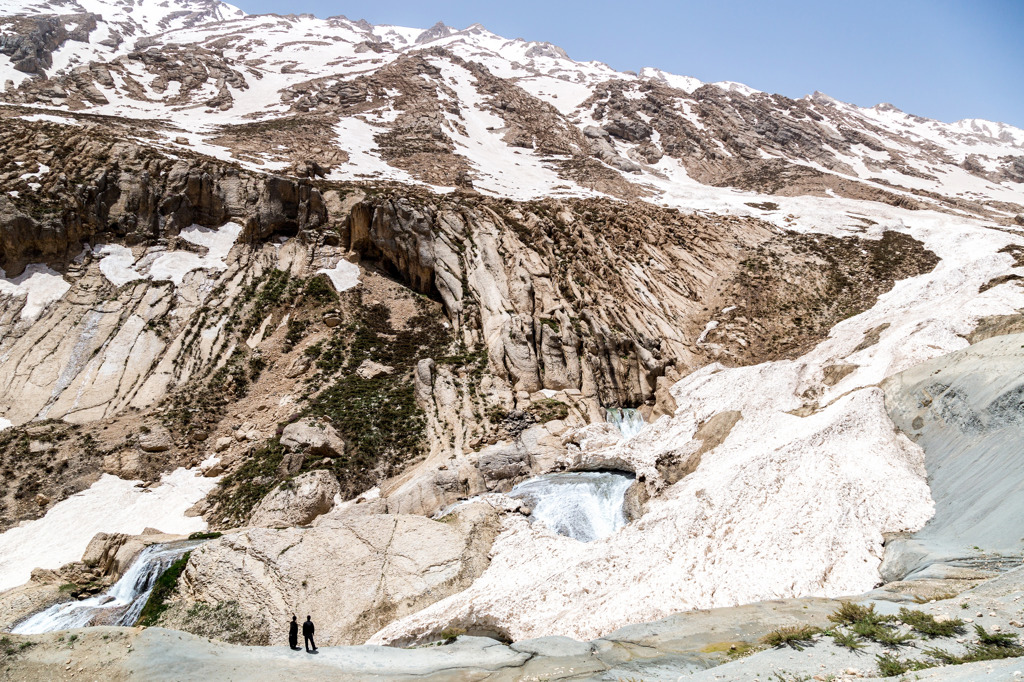 Besneeuwde bergen en smeltwaterval in Iran tijdens een groepsrondreis.