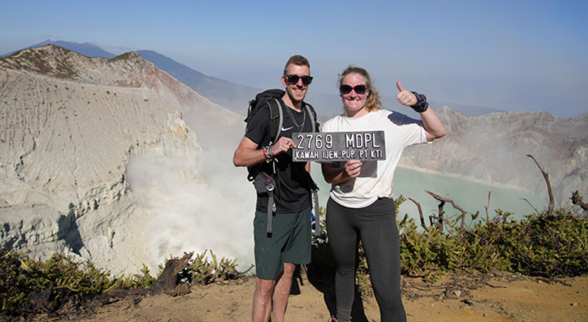 Ijen-vulkaan Java Twee hikers poseren bij Kawah Ijen met bord “2769 MDPL” en uitzicht op het kratermeer.