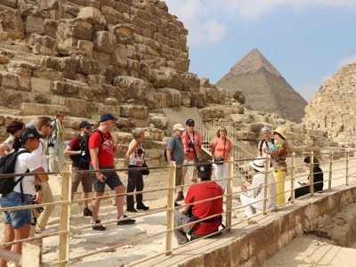 Groep reizigers bij de piramides van Gizeh tijdens route Egypte, met de Grote Piramide op de achtergrond.