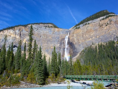 Waterval in de Canadese Rockies met dennenbos en brug over een rivier, Route Canada.
