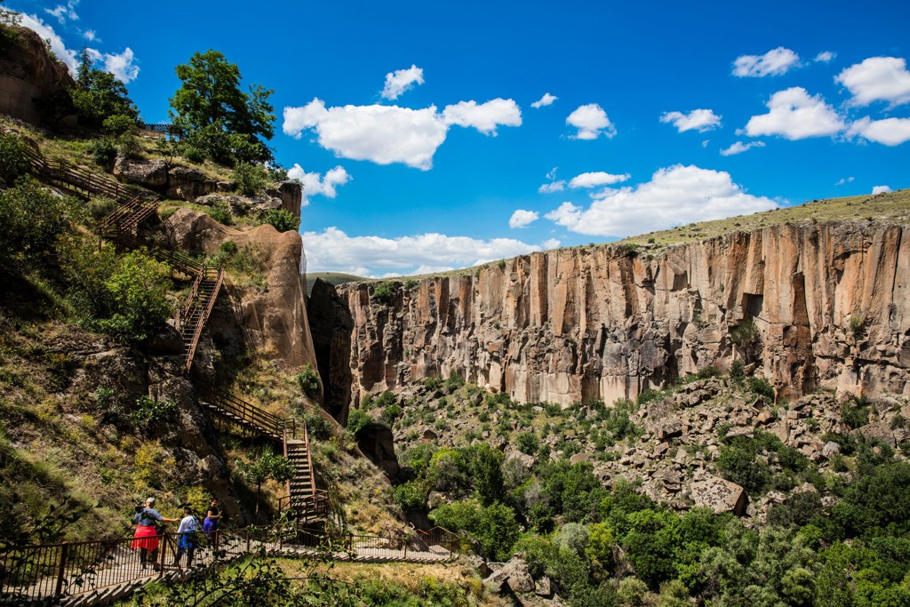 Wandelaars op een trap langs een rotswand in een kloof in Cappadocië, Turkije.
