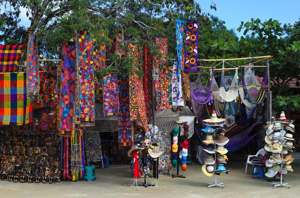 Kleurrijke markt in Mexico met handgemaakte textiel, hangmatten en hoeden.