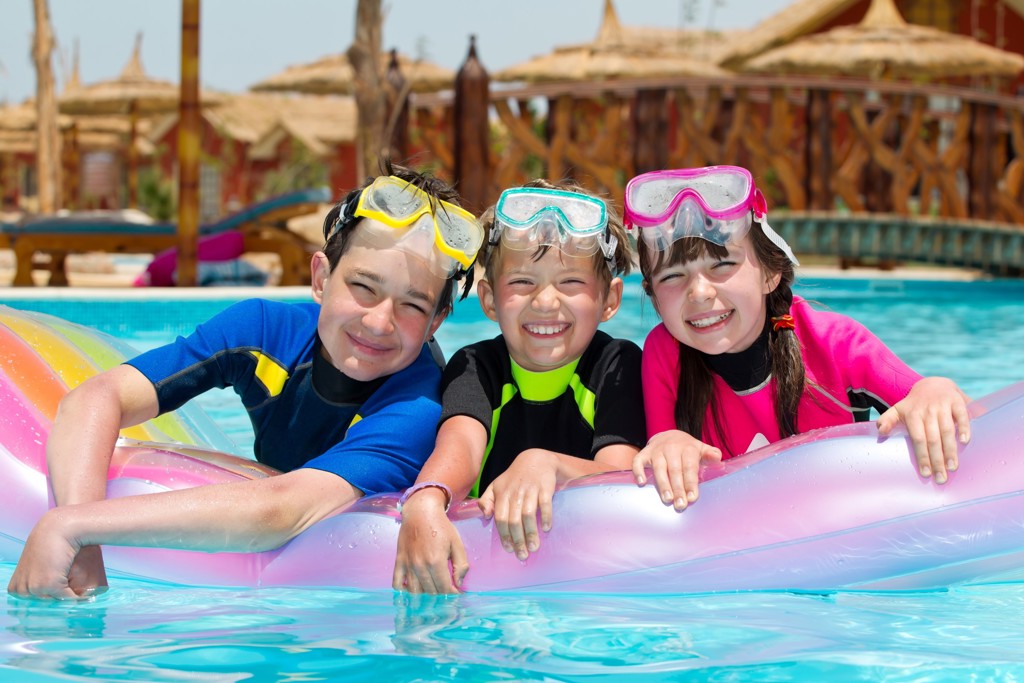 Kinderen met snorkelmaskers op een luchtbed in het zwembad tijdens een familiereis Egypte langs de Nijl.