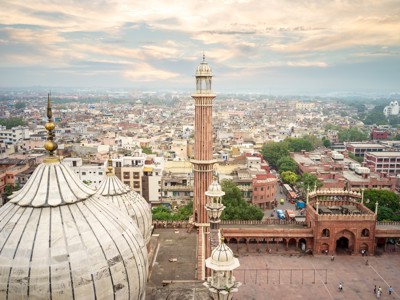 Uitzicht vanaf de Jama Masjid in Delhi met minaret en koepels, met de stad op de achtergrond.