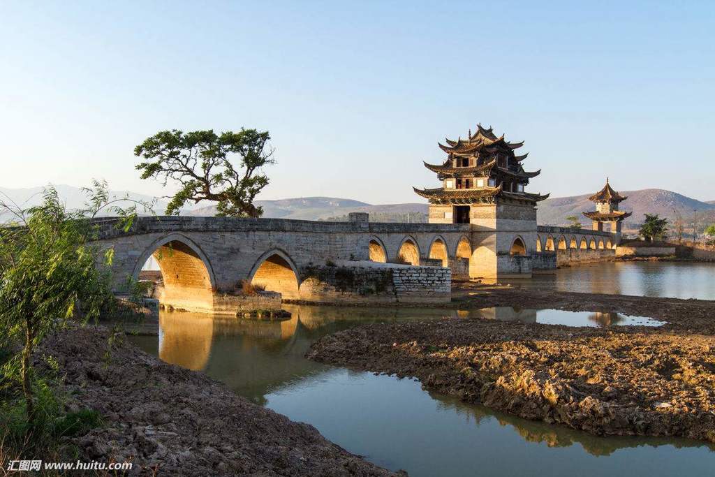 Oude stenen boogbrug met traditionele Chinese paviljoens over een rivier, tijdens de groepsrondreis China & Vietnam.