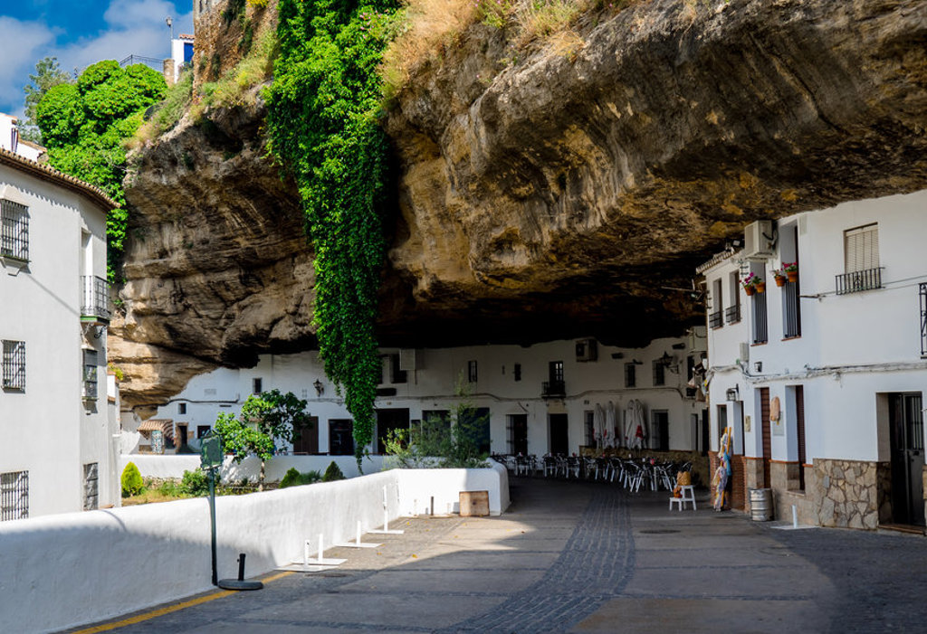 Witte huizen onder een grote rotswand in Setenil de las Bodegas, tijdens familiereis Spanje & Portugal.