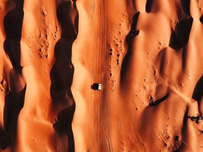 4x4 rijdt door hoge zandduinen in de woestijn van Oman tijdens de Route Oman en Dubai.