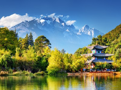 Traditioneel paviljoen bij een meer met uitzicht op de besneeuwde Jade Dragon Snow Mountain in Lijiang, China.