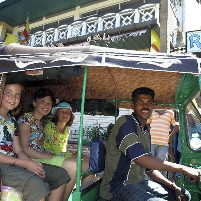 Gezin in een tuktuk tijdens een familiereis door Sri Lanka.