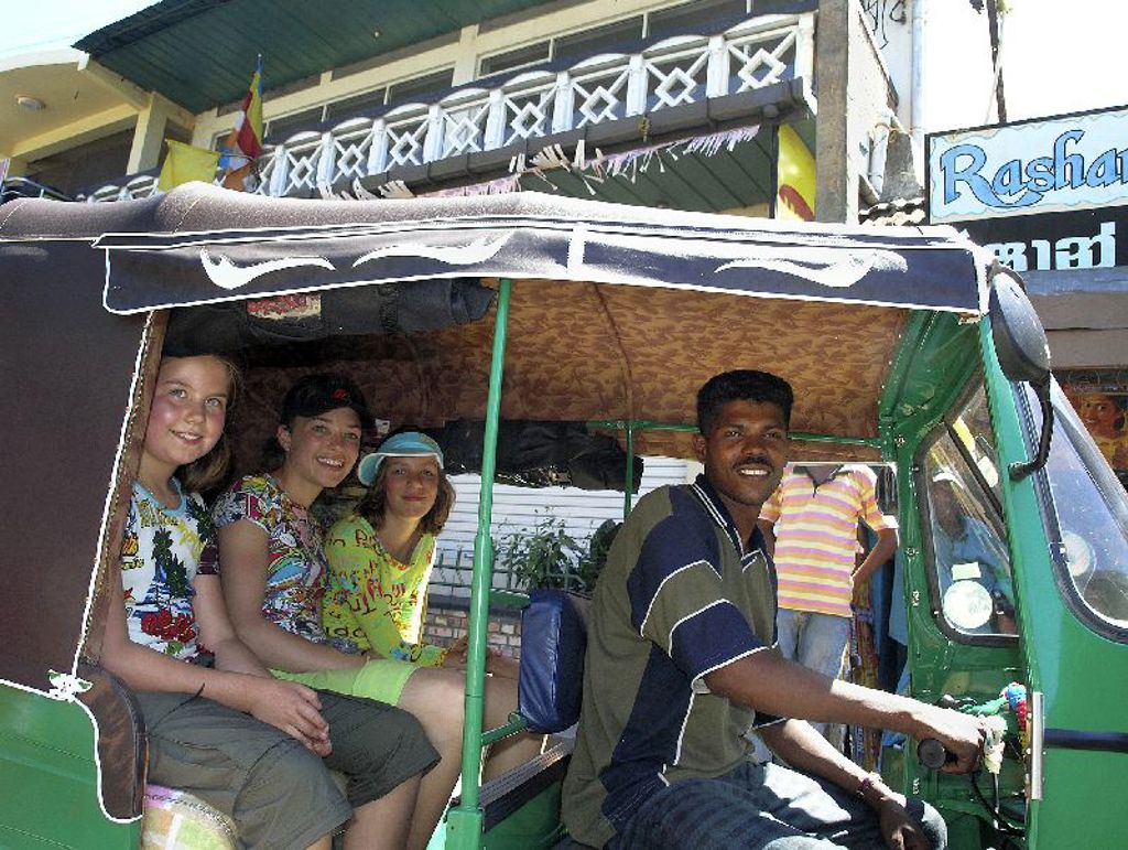 Gezin in een tuktuk tijdens een familiereis door Sri Lanka.