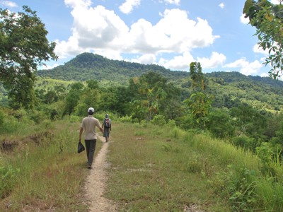 Wandelaars op een smal pad door groen heuvellandschap op Timor tijdens de 22-daagse route Timor, Sumba & Bali.