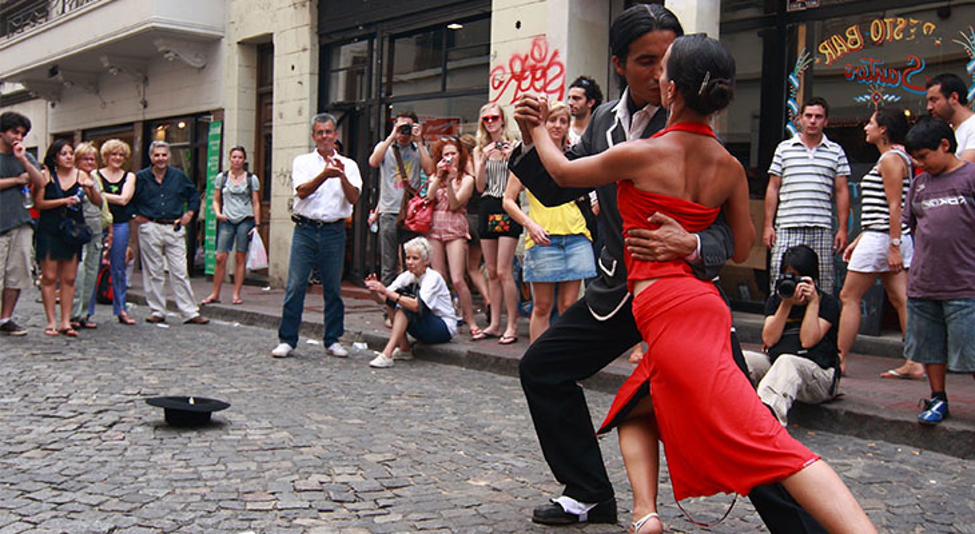 Tango dans Buenos Aires Tango danspaar danst op straat in Buenos Aires, Argentinië, met toeschouwers op de achtergrond.