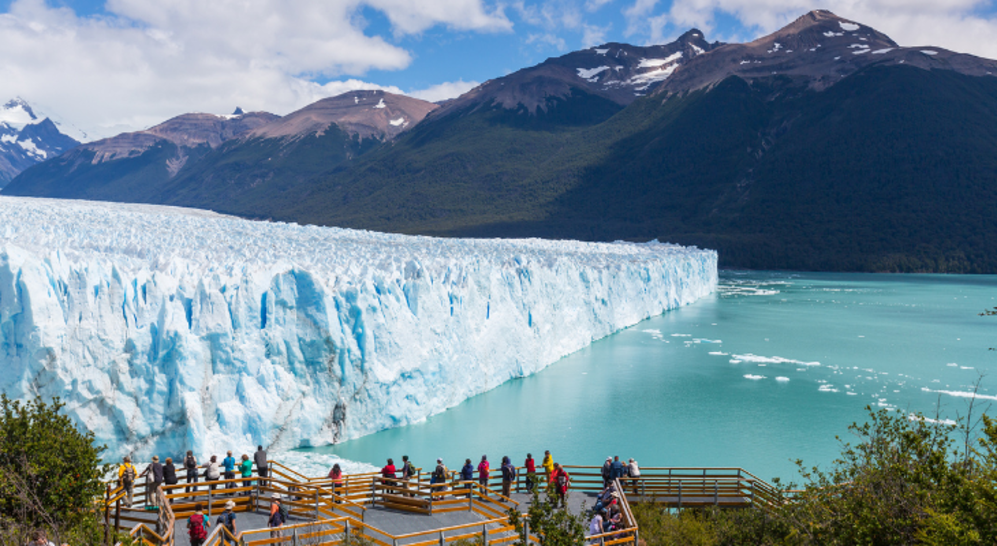 Uitzicht op de Perito Moreno-gletsjer met uitkijkplatform en bezoekers aan het turquoise water, Patagonië.