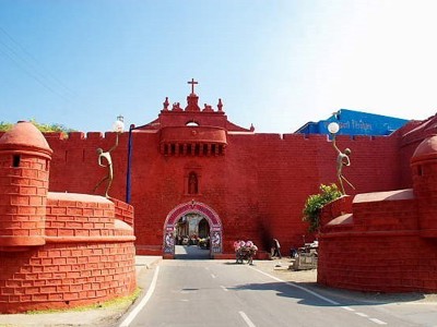 Rode stadspoort in Gujarat met weg erdoorheen en twee ronde wachttorens.