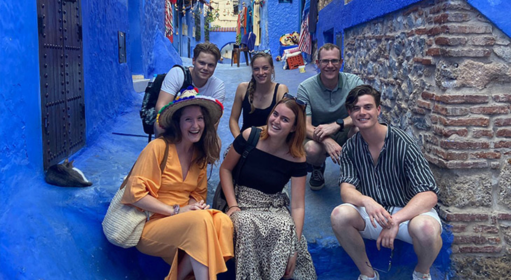 Chefchaouen Marokko Jonge reizigers van 22-35 jaar poseren in een smalle blauwe straat tijdens een Sawadee groepsreis.