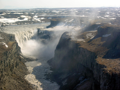 Waterval Dettifoss in Noord-IJsland, met mist boven de diepe kloof en ruig lavalandschap.
