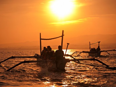Traditionele boottocht bij zonsondergang op zee tijdens de Route Java en Bali.