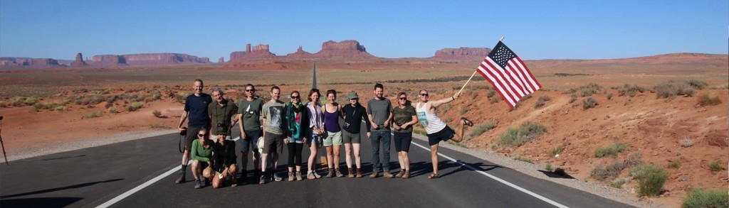 Groepsrondreis door het Wilde Westen: reizigers op de weg in Monument Valley met rotsformaties op de achtergrond.