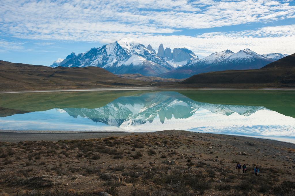 Besneeuwde bergtoppen en het Torres del Paine-massief weerspiegeld in een meer tijdens groepsrondreis Argentinië.