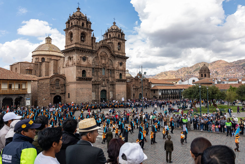 Drukke Plaza de Armas in Cusco met de kathedraal, tijdens een optocht op groepsrondreis Peru.