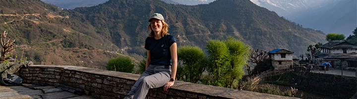 Wandelaarster pauzeert tijdens de Ghorepani trekking met uitzicht op de Himalaya in Nepal.