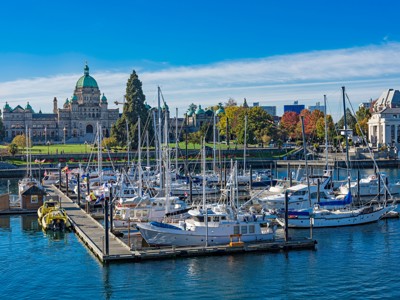 Jachthaven in Victoria met zeilboten en het parlementsgebouw van British Columbia op de achtergrond.