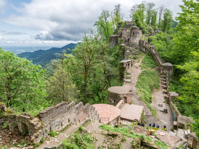 Ruïnes van kasteel Rudkhan op een beboste heuvelrug in Iran, met trappen en uitzicht over de bergen.