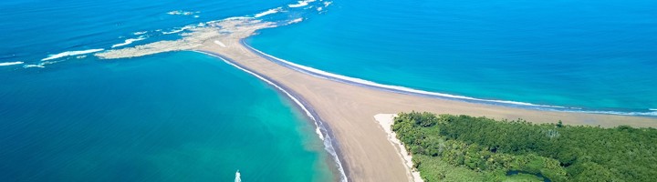 de Walvisstaart-zandbank bij Uvita, Costa Rica, met oceaan en groene kuststrook.
