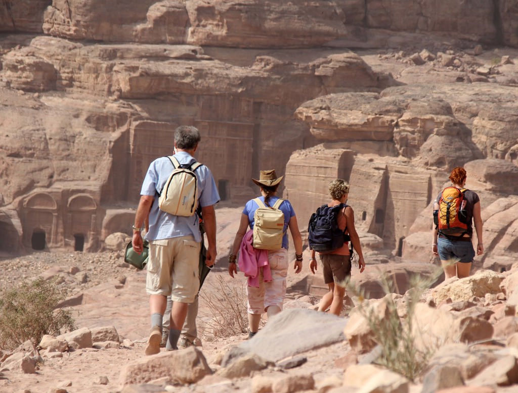 Wandelaars met rugzakken in de rotsstad Petra, Jordanië, tijdens groepsrondreis Israël en Jordanië.
