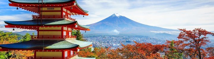Traditionele Japanse pagode met rode herfstbladeren in de voorgrond.