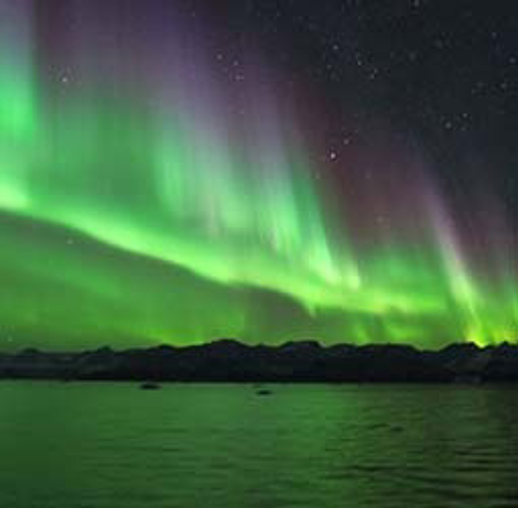 Noorderlicht boven een fjord in Groenland tijdens een groepsrondreis.
