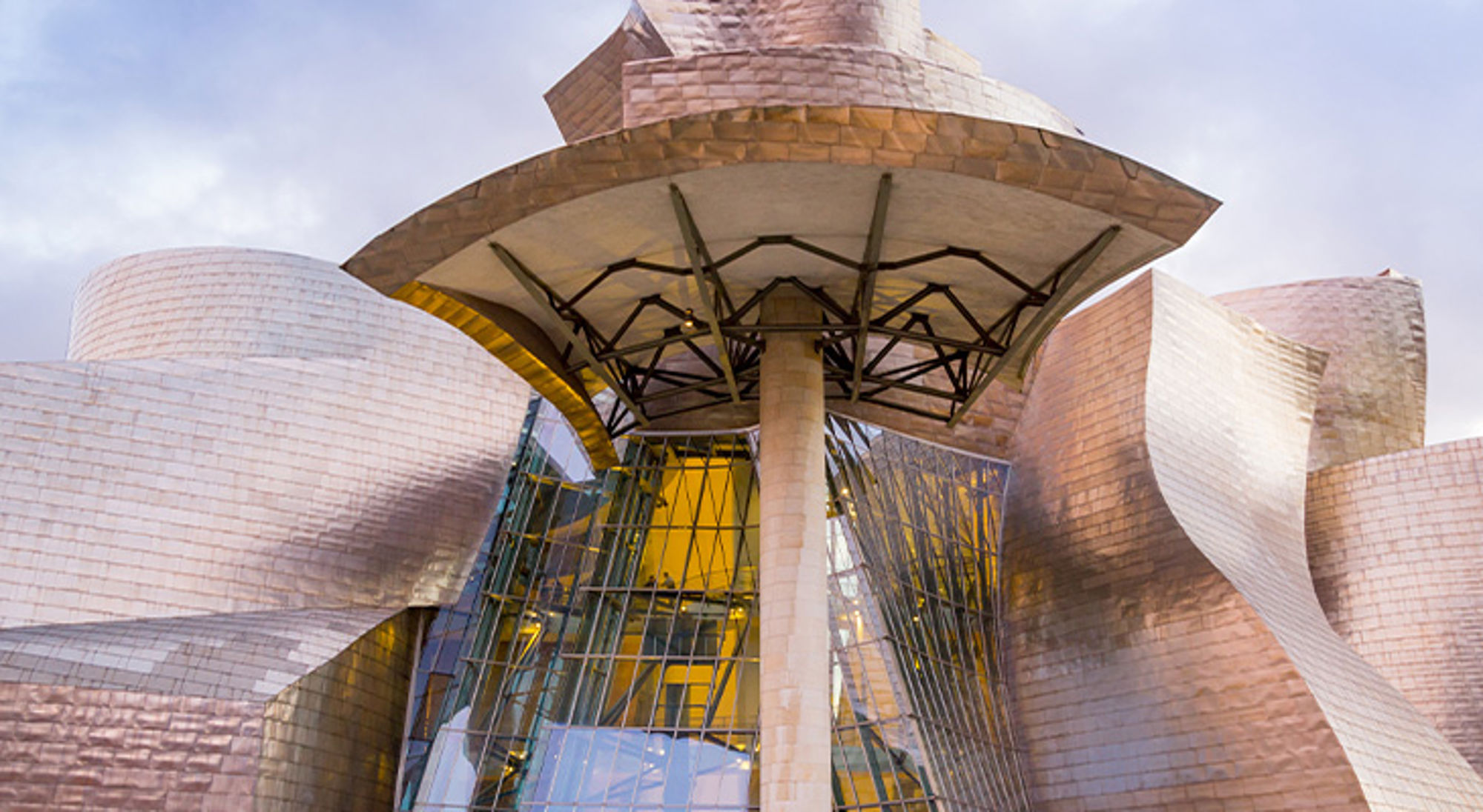 Guggenheim Bilbao Guggenheim Museum Bilbao met golvende titanium gevel en glazen entree onder een grote luifel.