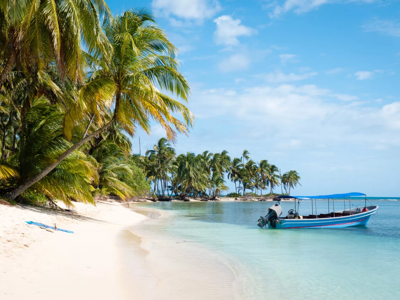 Palmenstrand met boot in helderblauw water langs de route Nicaragua, 23 dagen.
