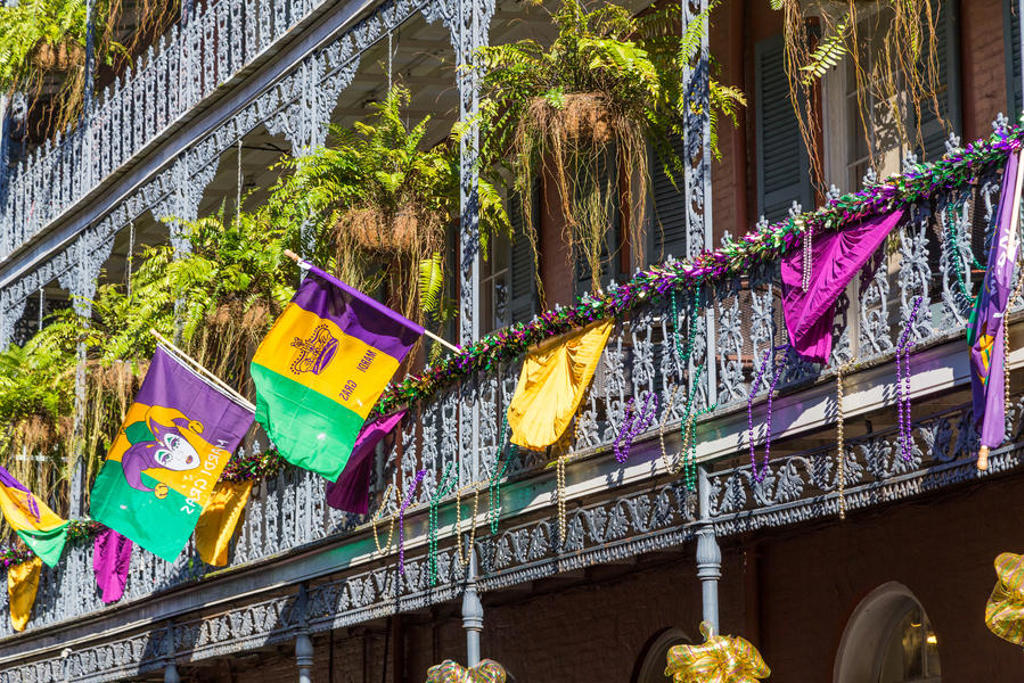 Balkon in New Orleans met Mardi Gras-vlaggen, kralen en hangplanten in het French Quarter.