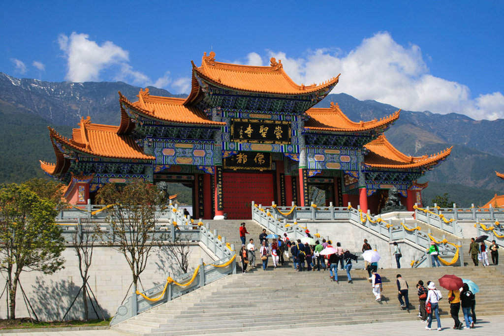 Traditionele Chinese tempel met oranje dak en bezoekers, tegen de bergen tijdens een groepsrondreis China.