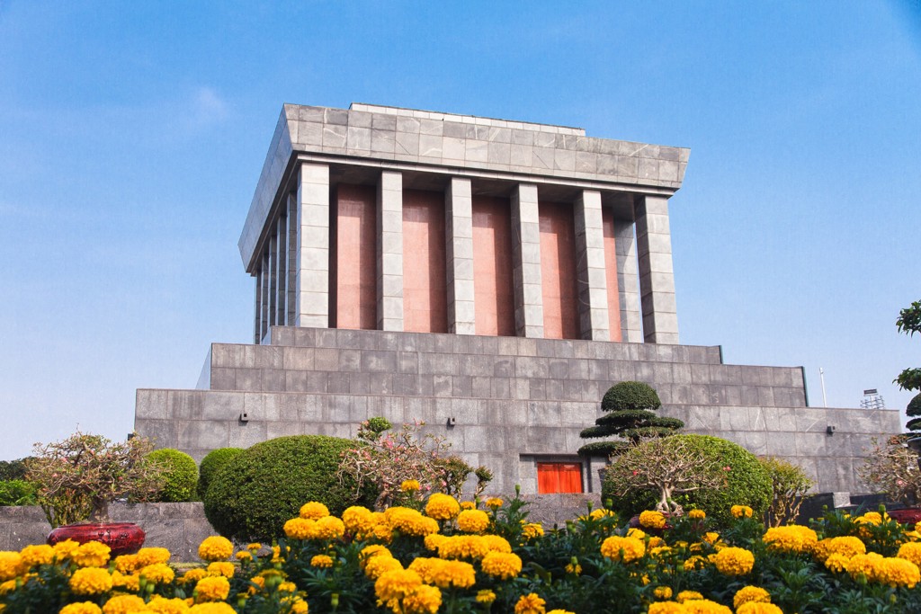 Ho Chi Minh Mausoleum in Hanoi met bloeiende gele bloemen, onderdeel van de Route Vietnam.