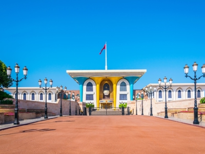 Sultan Qaboos-paleis Al Alam in Muscat, Oman, met kleurrijke zuilen en Omaanse vlag.