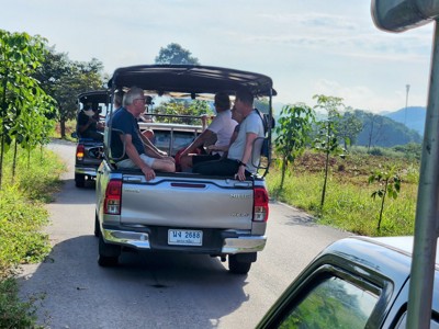 Pick-up taxi’s met reizigers op een landelijke weg in Thailand tijdens de Route Thailand.