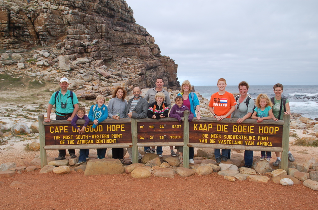 Gezin bij het bord van Kaap de Goede Hoop tijdens een familiereis door Zuid-Afrika en eSwatini.