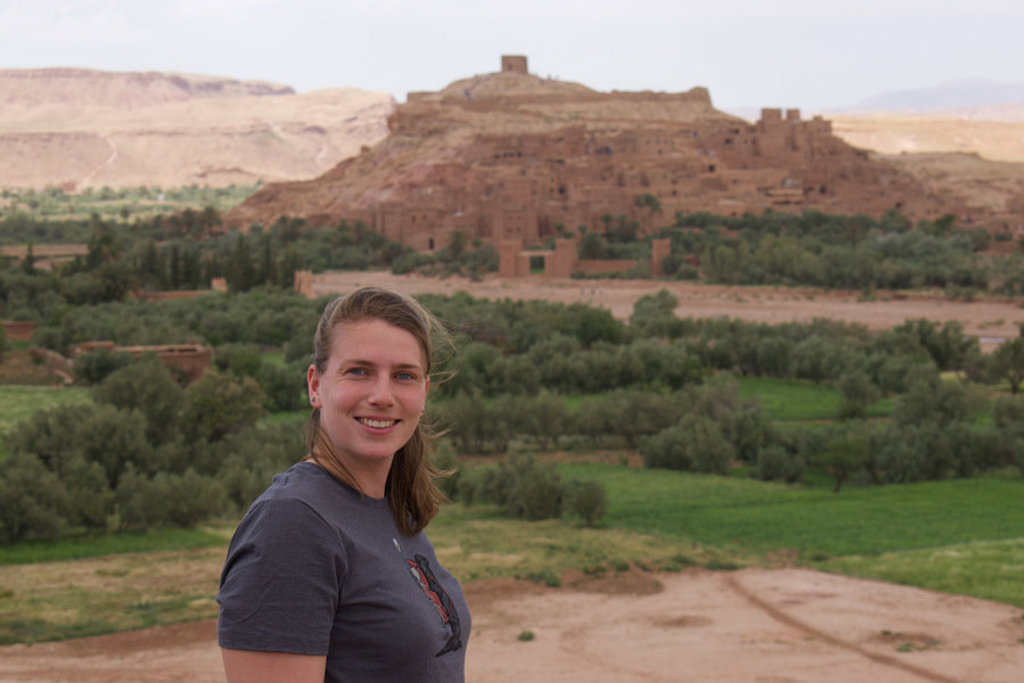Reiziger bij Aït Ben Haddou, iconische kasbah tijdens groepsrondreis Marokko hoogtepunten.