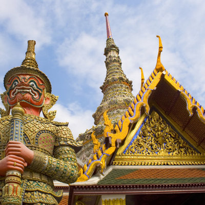 Gouden tempelwachter en pagode bij een Thaise tempel, hoogtepunten van een familiereis door Thailand.
